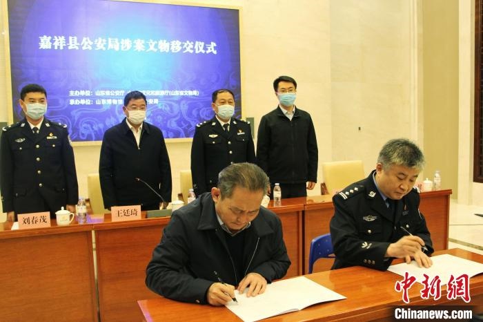 山東博物館館長(zhǎng)鄭同修和嘉祥縣人民政府副縣長(zhǎng)、公安局局長(zhǎng)趙健簽署移交協(xié)議?！≮w曉 攝