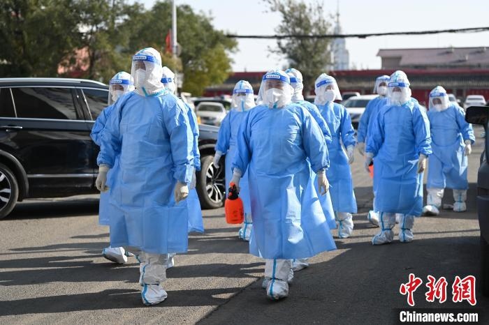 圖為醫(yī)務人員在封閉小區(qū)做防控工作?！⑽娜A 攝
