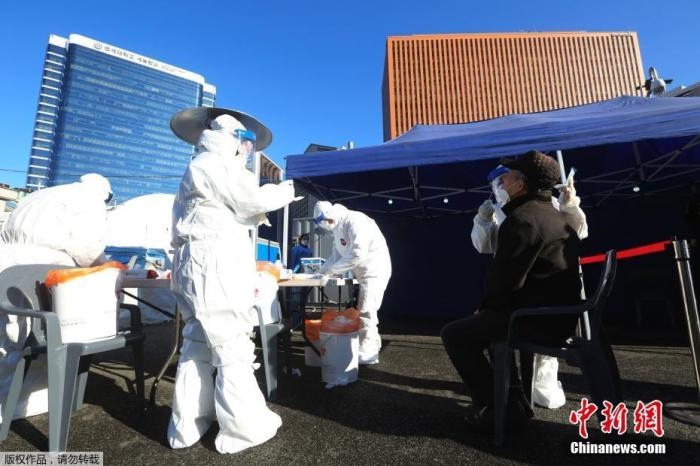 資料圖：韓國(guó)首爾，醫(yī)務(wù)人員對(duì)市民進(jìn)行新冠病毒檢測(cè)。