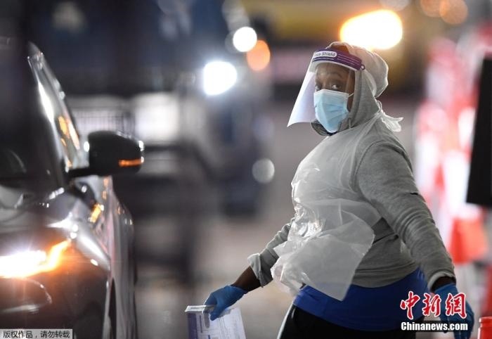 當?shù)貢r間12月18日，英國政府公布的數(shù)據(jù)顯示，當天英國新增奧密克戎毒株感染病例10059例。鑒于奧密克戎毒株感染病例激增，住院人數(shù)不斷上升，倫敦市長宣布倫敦進入“重大事故”狀態(tài)。圖為倫敦的一個免下車檢測中心，一名醫(yī)務工作者正準備對司機進行核酸檢測。