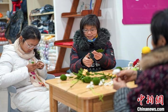 文創(chuàng)工作室的姐妹們正在鉤織月桂葉片。　古良駒 攝