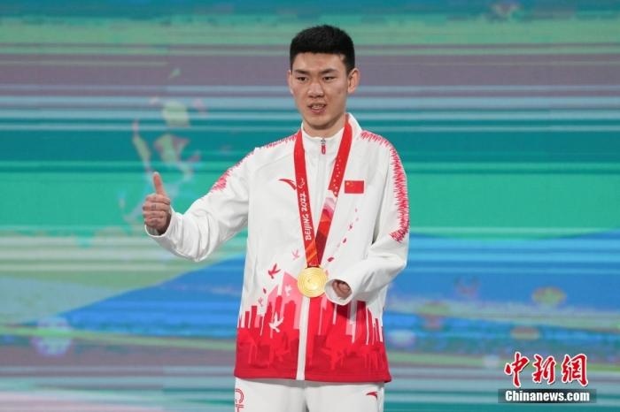 3月6日，梁景怡在延慶頒獎廣場領(lǐng)獎臺上豎起大拇指。當(dāng)日，在國家高山滑雪中心舉行的北京2022年冬殘奧會殘奧高山滑雪男子超級大回轉(zhuǎn)—站姿決賽中，中國選手梁景怡奪得冠軍。 <a target='_blank' href='/'>中新社</a>記者 楊華峰 攝