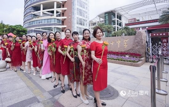 6月7日一早，廈門雙十中學(xué)考生家長們身穿旗袍，手拿向日葵在考場外為孩子加油打氣，寓意“旗開得勝，一舉奪魁”。人民網(wǎng)記者 陳博攝