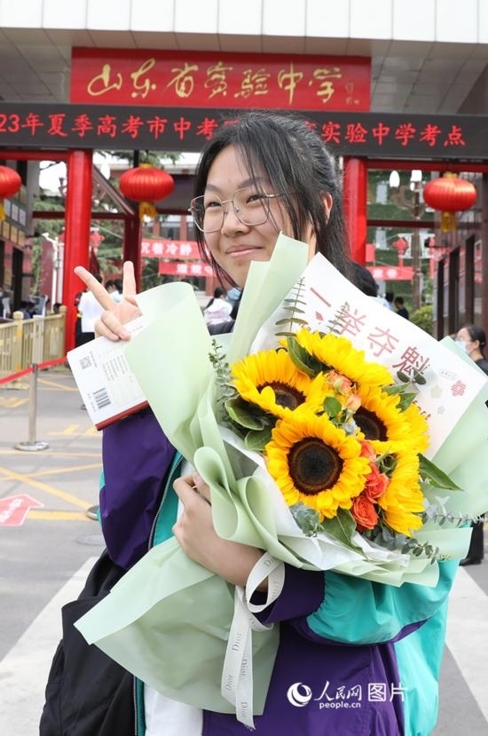 6月7日高考首日，山東67萬考生走進(jìn)考場，拼搏逐夢。在山東省實驗中學(xué)考點，考生進(jìn)考場前手捧向日葵花拍照留念，寓意“一舉奪魁”。人民網(wǎng)記者 劉祺攝