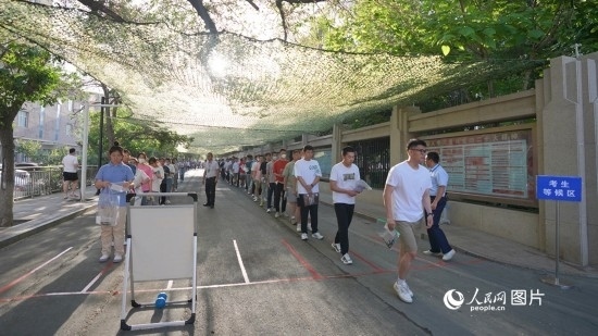 6月7日，烏魯木齊市第七十中學(xué)門口，考生們有序進(jìn)入考場。人民網(wǎng) 李欣洋攝