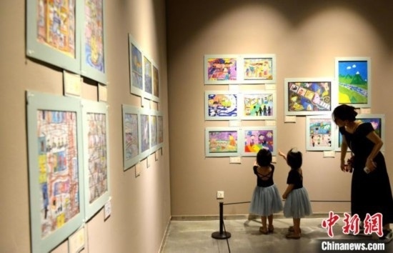 圖為家長(zhǎng)帶著孩子參觀展覽。呂明 攝