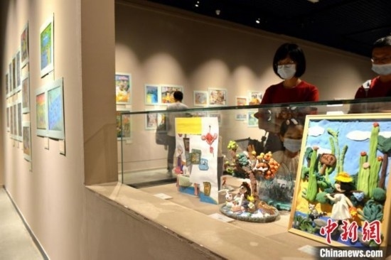 圖為家長(zhǎng)帶著孩子參觀展覽。呂明 攝