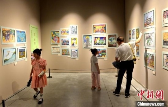 圖為家長(zhǎng)帶著孩子參觀展覽。呂明 攝