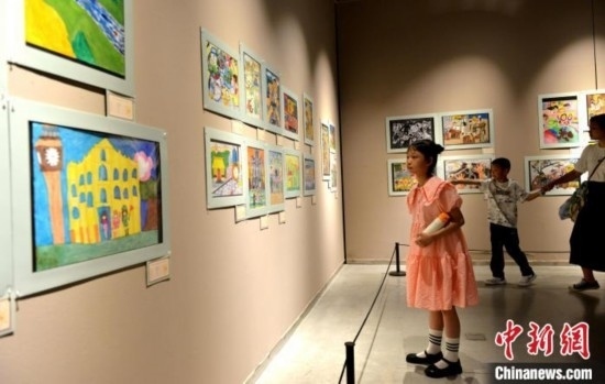 圖為家長(zhǎng)帶著孩子參觀展覽。呂明 攝