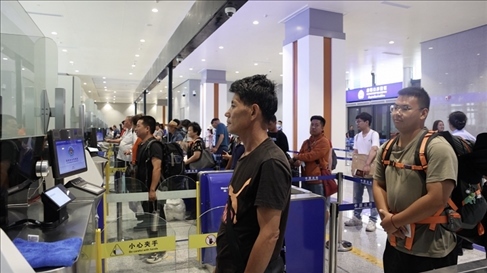 6月13日，乘坐中老鐵路國際旅客列車的旅客在磨憨邊檢大廳排隊(duì)候檢。李揚(yáng) 攝