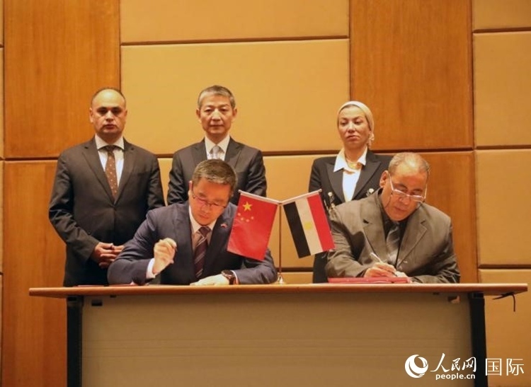 中國(guó)駐埃及使館公使張朝陽(yáng)與埃環(huán)境事務(wù)署工程和項(xiàng)目管理局局長(zhǎng)阿卜杜勒阿齊茲簽署交接證書(shū)。沈小曉攝