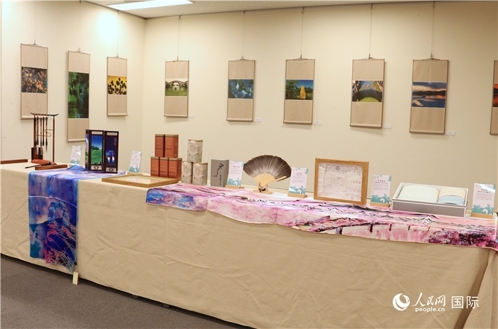 現(xiàn)場(chǎng)展出的馮學(xué)敏攝影作品與湖州市特色工藝品。（人民網(wǎng) 許可攝）