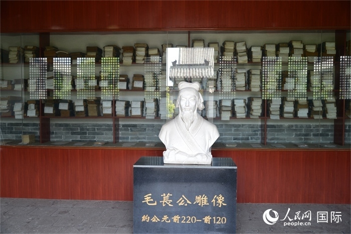 河間詩經齋毛萇雕像。雕像后書櫥中陳列的是歷代各版本《詩經》及譯本。 人民網 趙昭攝