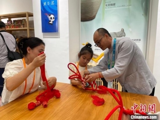 市民體驗(yàn)制作吉祥如意結(jié)。祝歡 攝