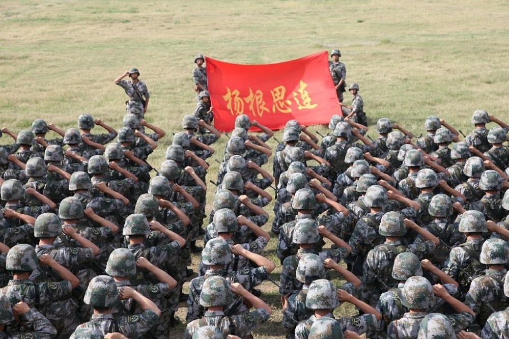 ↑“楊根思連”官兵執(zhí)行任務(wù)前向連旗宣誓（資料照片）。新華社發(fā)