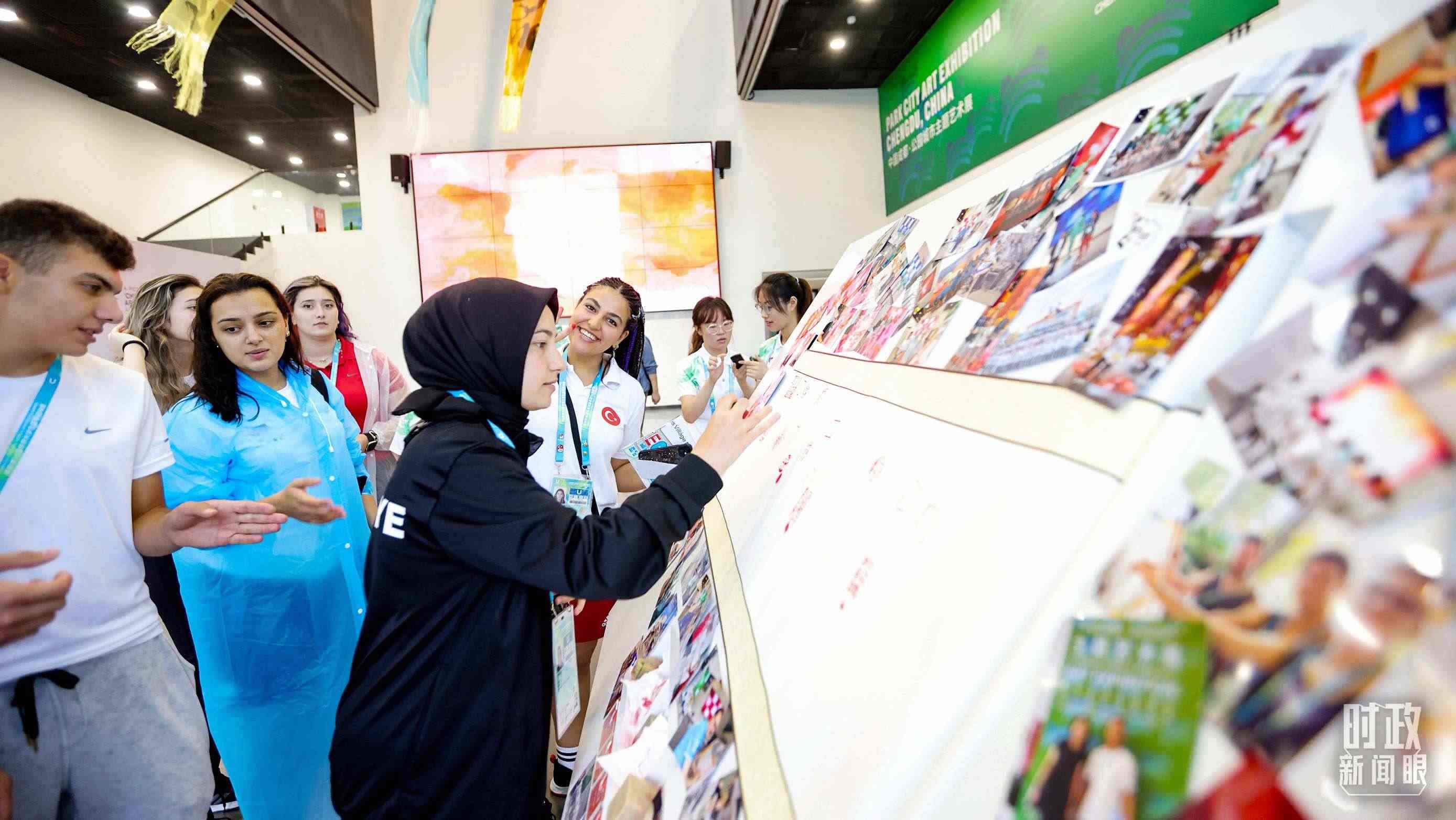 各國青年運動員正在參觀成都大運村內(nèi)的“雪山下的公園城市，煙火里的幸福成都”主題藝術(shù)展。（總臺央視記者魏幫軍拍攝）