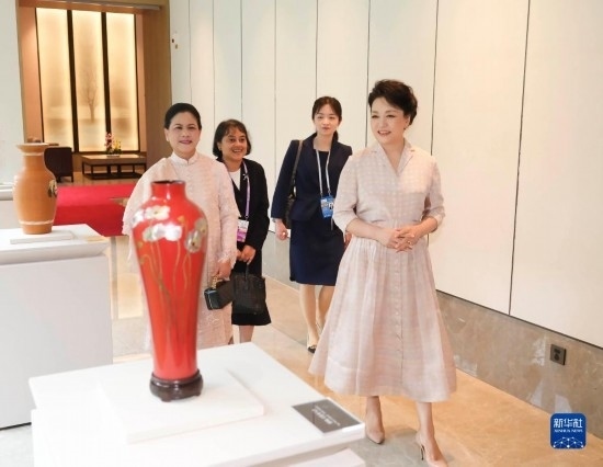 7月27日下午，國家主席習(xí)近平夫人彭麗媛在四川成都會見陪同印度尼西亞總統(tǒng)佐科來華出席第31屆世界大學(xué)生夏季運(yùn)動會開幕式并訪華的總統(tǒng)夫人伊莉亞娜。這是彭麗媛和伊莉亞娜欣賞成都特色非遺工藝品。新華社記者 丁林 攝