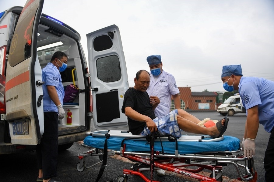 8月1日，在北京市門頭溝區(qū)妙峰山鎮(zhèn)妙峰山民族學(xué)校臨時安置點，北京急救中心工作人員在轉(zhuǎn)運一名受傷村民。新華社記者 鞠煥宗 攝