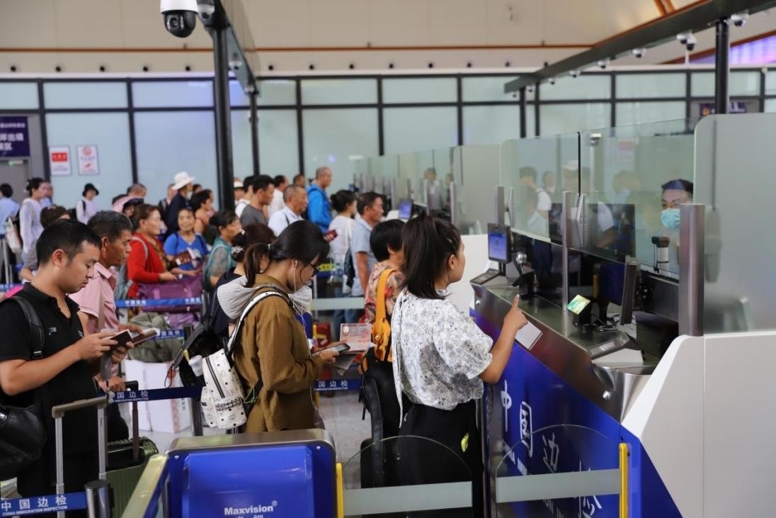 出境旅客在辦理通關(guān)手續(xù)。人民網(wǎng)記者 李發(fā)興攝