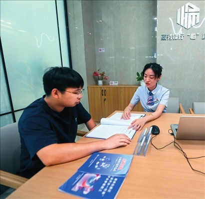 在杭州市臨安區(qū)政務(wù)服務(wù)中心的“為企服務(wù)中心”，黨員志愿者（右）解答企業(yè)主的疑問(wèn)（2023年7月7日攝）。徐昱攝/本刊