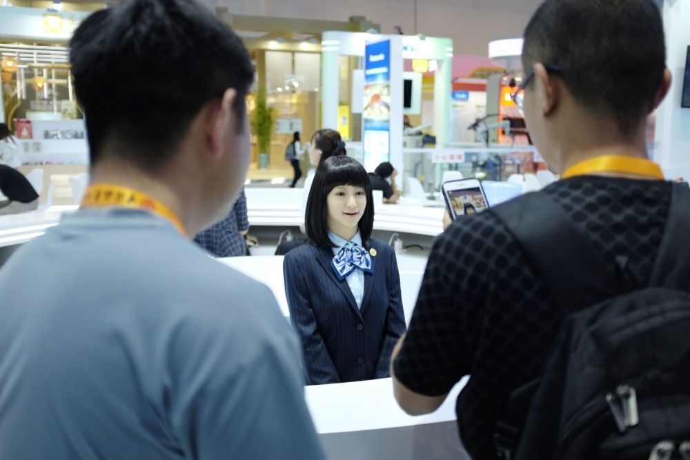 9月1日，媒體記者在國家會(huì)議中心與服務(wù)機(jī)器人互動(dòng)。新華社記者 劉夢琪 攝