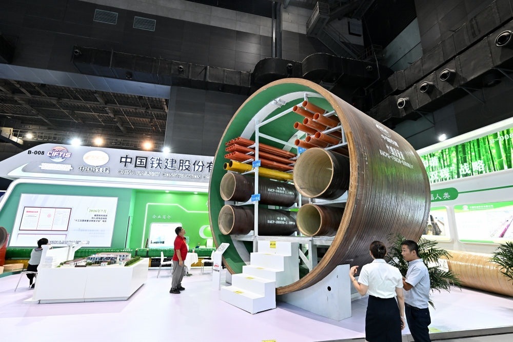 9月2日，在國家體育館舉行的服貿(mào)會(huì)環(huán)境服務(wù)專題展上，客商在中國鐵建展位竹纏繞管廊旁了解信息。新華社記者 李鑫 攝