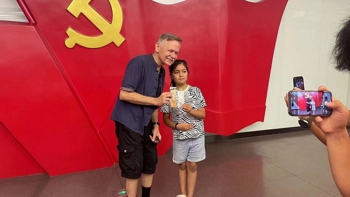 潘維廉和志愿講解員紀念合影。主辦方供圖