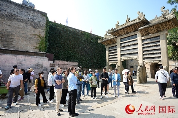 選手們認(rèn)真聆聽導(dǎo)游講解。人民網(wǎng) 盧鵬宇攝