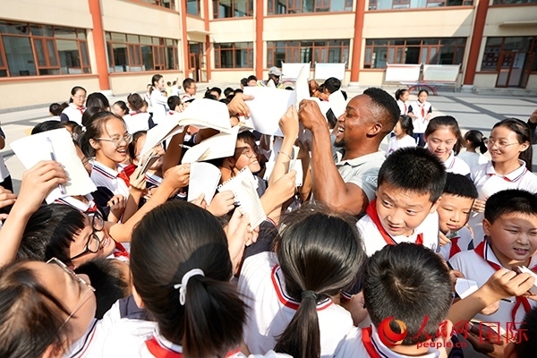 孩子們和選手互動(dòng)簽名。人民網(wǎng) 盧鵬宇攝