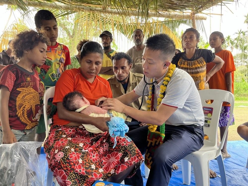 2023年8月5日，在巴布亞新幾內(nèi)亞中央省的一個(gè)村莊里，第12批援巴新中國醫(yī)療隊(duì)副隊(duì)長、新生兒科副主任醫(yī)師劉振球?yàn)楫?dāng)?shù)貗雰郝犜\檢查。新華社發(fā)（第12批援巴新中國醫(yī)療隊(duì)供圖）