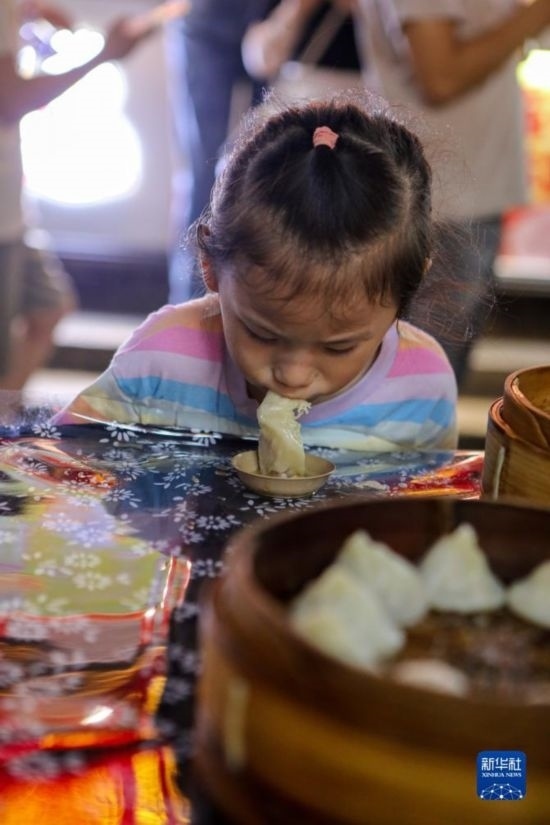 9月27日，小朋友在南翔小籠長街宴上品嘗南翔小籠。