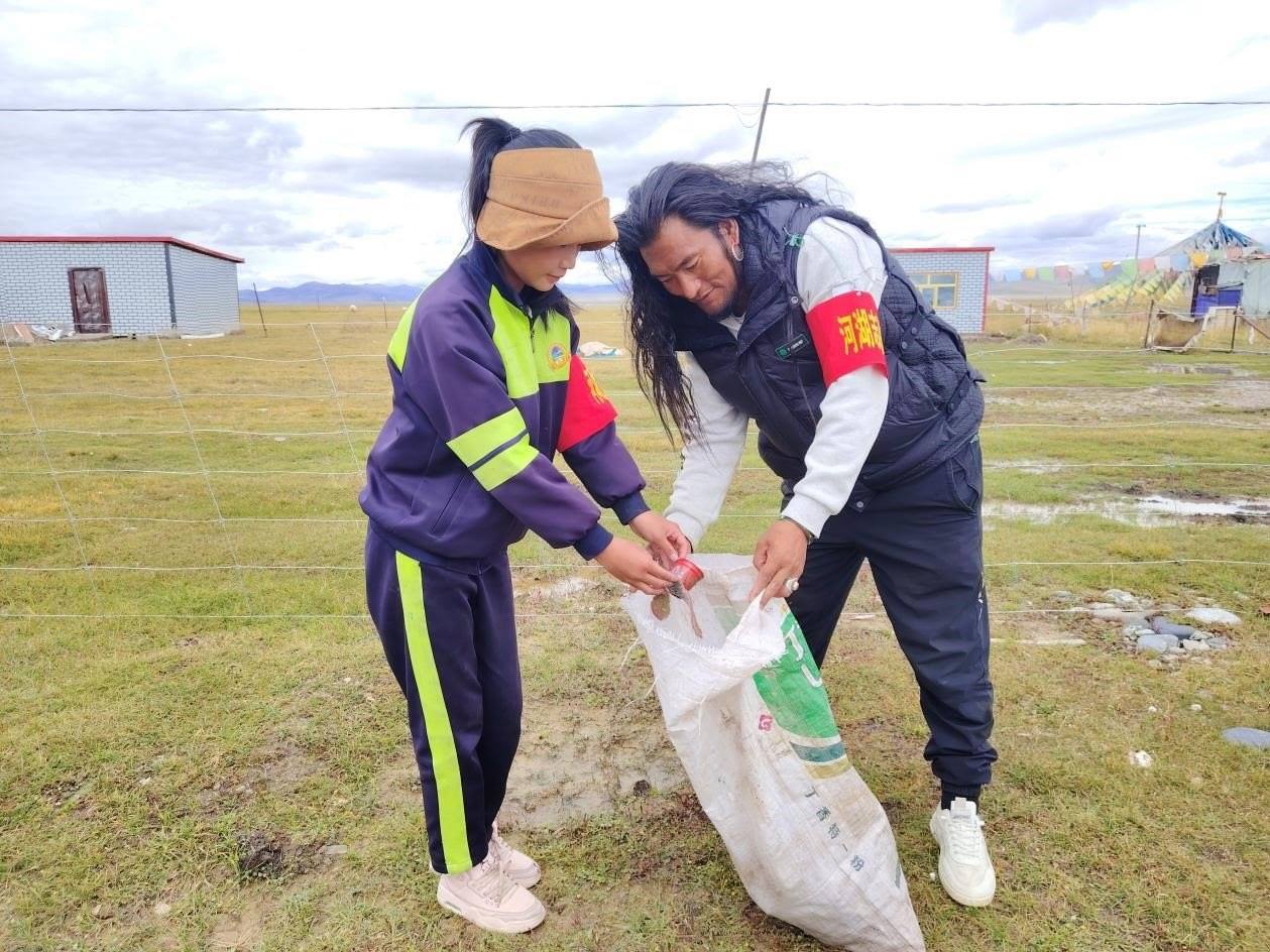玉樹州稱多縣珍秦鎮(zhèn)河湖志愿者才培和他女兒更求拉毛在清掃垃圾。受訪者供圖