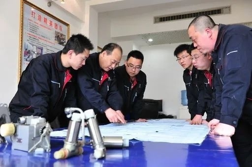 △李志強(qiáng)（左二）與班組成員在研究工作。