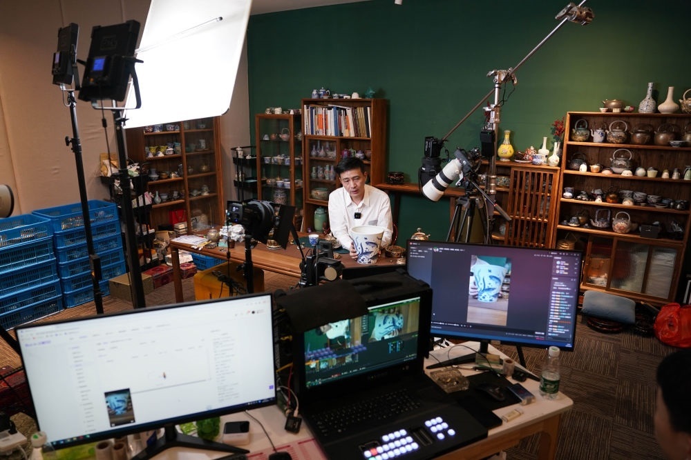 ↑在景德鎮(zhèn)，工作人員通過(guò)網(wǎng)絡(luò)直播推介陶瓷產(chǎn)品（2023年2月22日攝）。