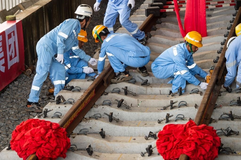 3月31日，在印度尼西亞雅加達(dá)雅萬高鐵哈利姆車站，工人鋪設(shè)雅萬高鐵全線最后一根鋼軌。