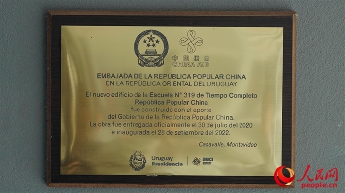 小學墻上懸掛的中國援助標識。人民網(wǎng)記者 張若涵攝