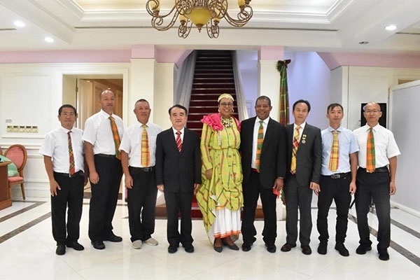 多米尼克總統(tǒng)伯頓和駐多米尼克大使林先江與中國(guó)農(nóng)業(yè)技術(shù)專家組合影。中國(guó)駐多米尼克大使館供圖