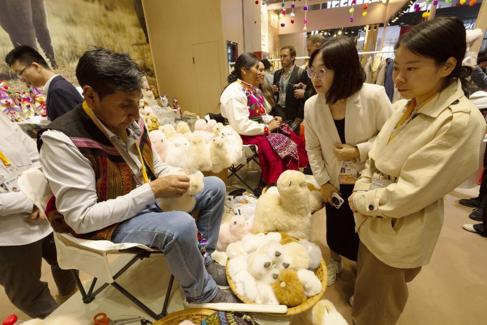 2023年11月7日，秘魯羊駝毛制品手藝人馬馬尼大叔在中國上海舉辦的第六屆進博會上展示羊駝玩偶制作工藝。秘魯特色羊駝毛制品連續(xù)六屆在進博會上亮相，收獲大量訂單。進博會大舞臺讓秘魯傳統(tǒng)手藝人有了更廣闊的發(fā)展空間。