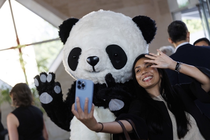 2022年8月24日，在美國華盛頓中國駐美國大使館，來賓與大熊貓玩偶合影。