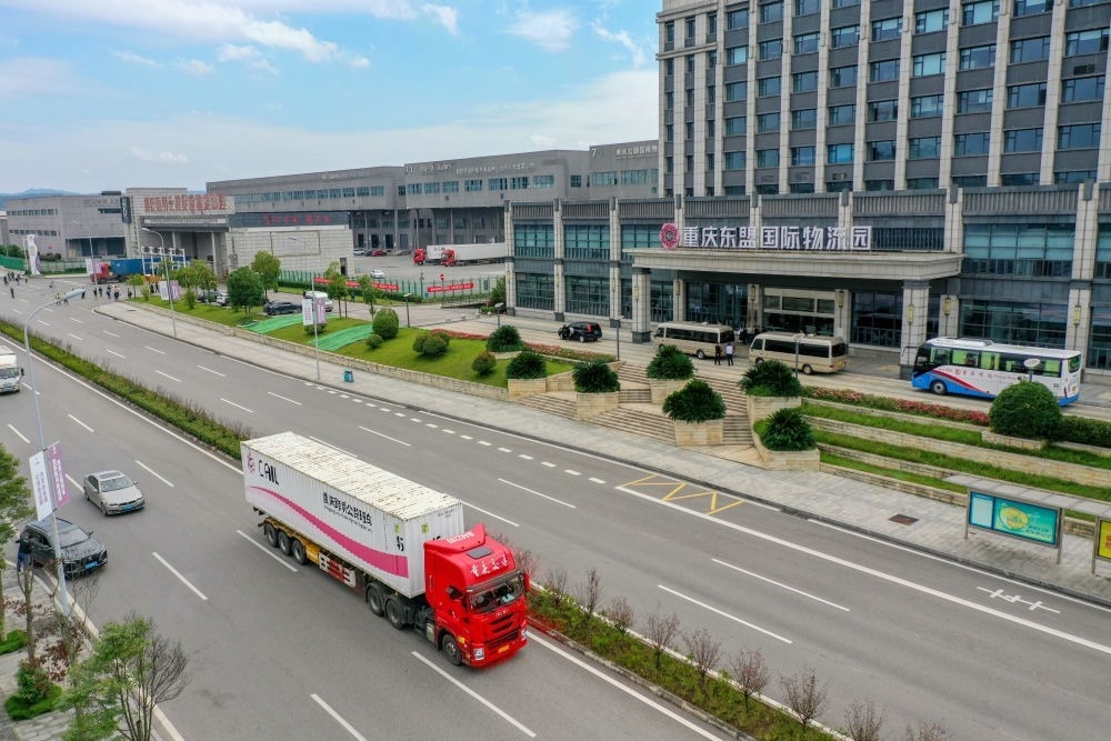 2023年10月11日，滿載筆記本電腦配件、發(fā)電機(jī)組件等產(chǎn)品的西部陸海新通道跨境公路班車從重慶南彭公路保稅物流中心駛出，將途經(jīng)廣西憑祥，直達(dá)越南（無(wú)人機(jī)照片）。新華社記者 黃偉 攝