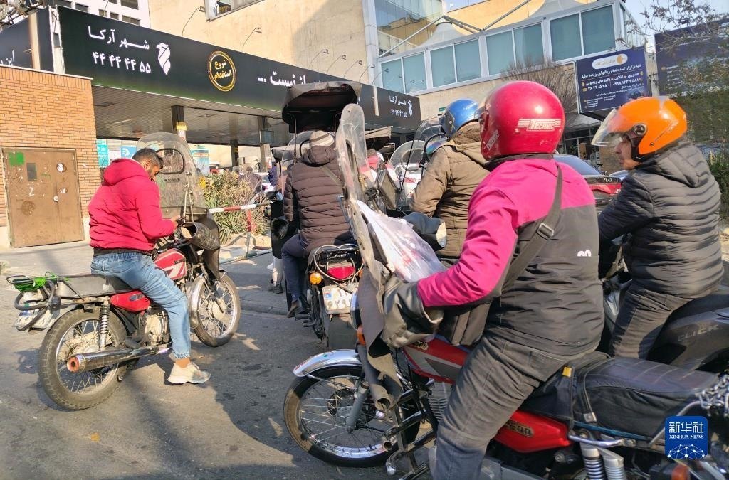 12月18日，摩托車在伊朗首都德黑蘭的一家加油站外等待加油。新華社記者 沙達提 攝
