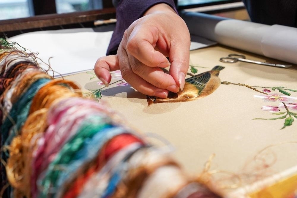 △2023年7月6日，盧建英在江蘇蘇州平江路的工作室內(nèi)刺繡。