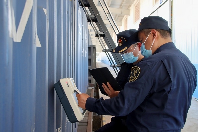 海關(guān)關(guān)員使用手持式輻射探測儀對中老鐵路入境貨物進(jìn)行檢測。張釋巍攝