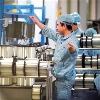 在位于武漢的長(zhǎng)飛光纖光纜股份有限公司光纖生產(chǎn)車間內(nèi)，工作人員對(duì)光纖進(jìn)行檢測(cè)（資料圖片）。肖藝九攝/本刊