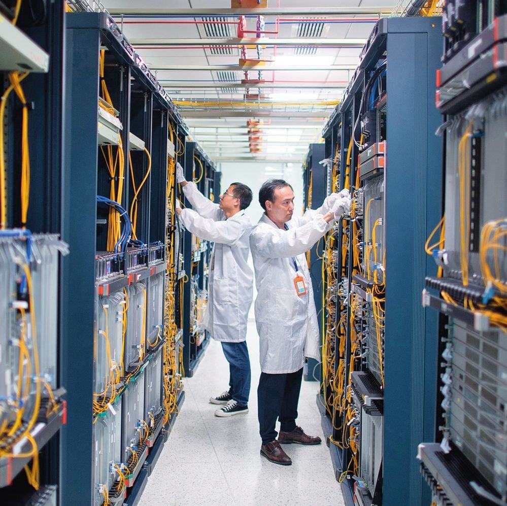 在位于武漢中國(guó)光谷的光電器件研發(fā)制造商——武漢光迅科技股份有限公司生產(chǎn)車間內(nèi)，技術(shù)人員在光模塊生產(chǎn)線作業(yè)（2023年4月11日攝）。程敏攝/本刊