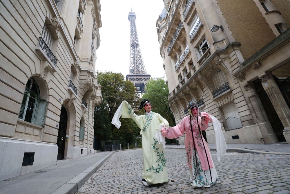 2023年9月13日，江蘇省演藝集團(tuán)昆劇院院長施夏明（左）和江蘇省演藝集團(tuán)昆劇院國家一級演員孔愛萍在法國巴黎埃菲爾鐵塔附近參加昆曲快閃。新華社記者 高靜 攝