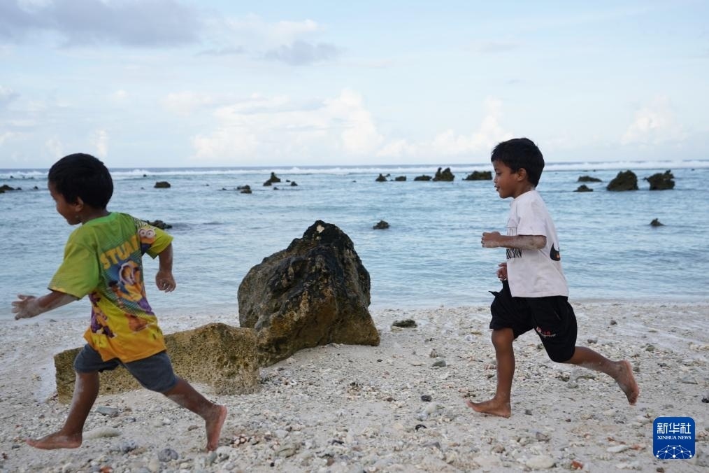 1月20日，兒童在瑙魯海邊嬉戲。新華社記者 王申 攝