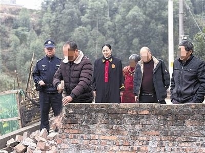  圖③：庭審結(jié)束后，在法官的見證下，陳某在院壩邊重新開鑿一條通道。