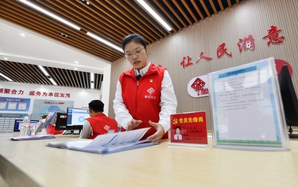 △2023年12月14日，廣西南寧市蟠龍社區(qū)，工作人員在為居民服務(wù)。