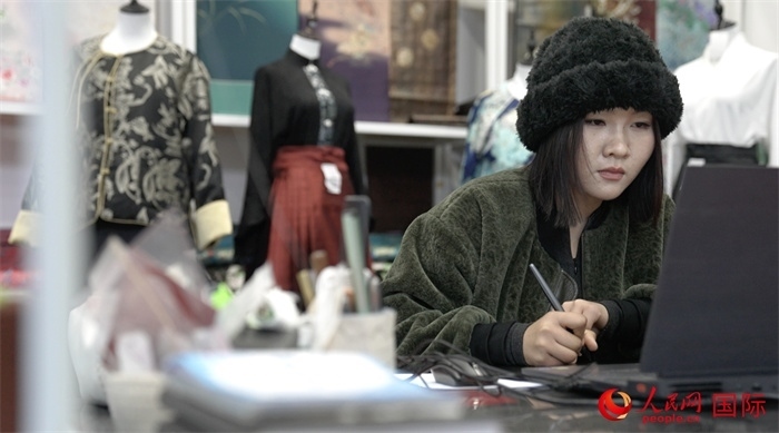 1月23日，在山東省菏澤市曹縣有愛云倉直播基地，張子晨正在設(shè)計漢服。 人民網(wǎng)記者 袁蒙攝